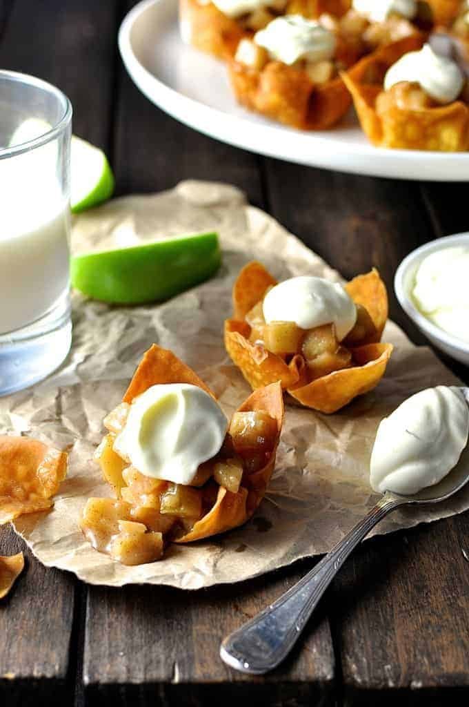 Mini Apple Pies made with wonton cups with a dollop of cream, ready for serving.