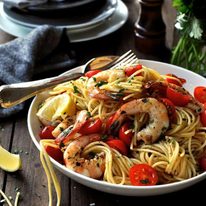 A bowl of Prawn Pasta with cherry tomatoes and lemon