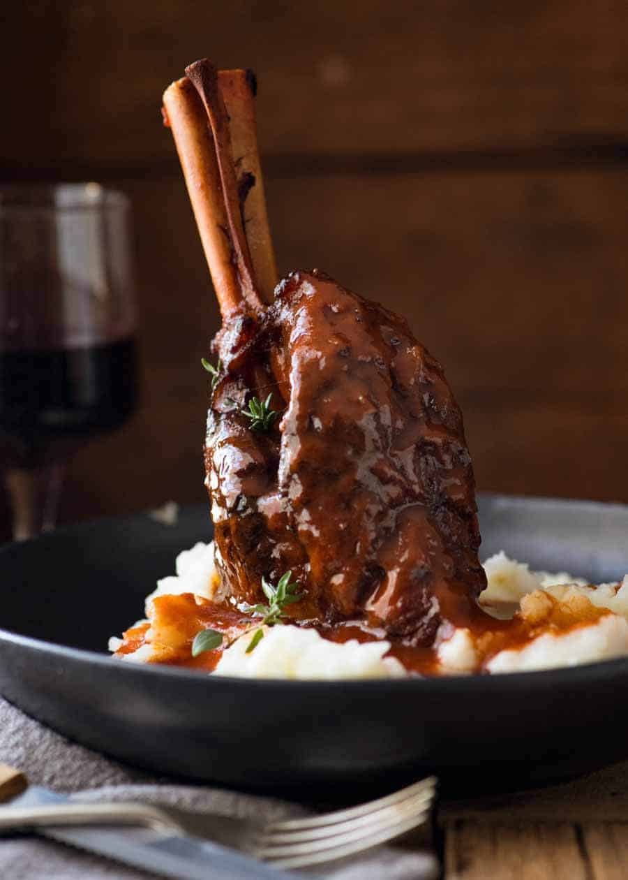 Slow Cooked Lamb Shanks in Red Wine Sauce served on creamy mashed potato, ready to be eaten