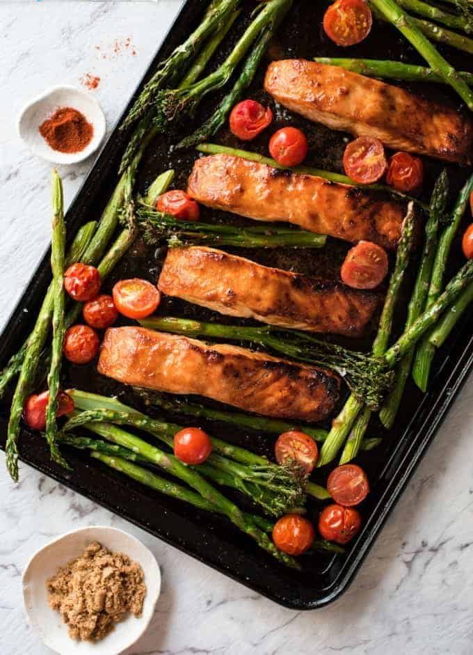 Spicy Brown Sugar Salmon on a tray with asparagus and tomatoes