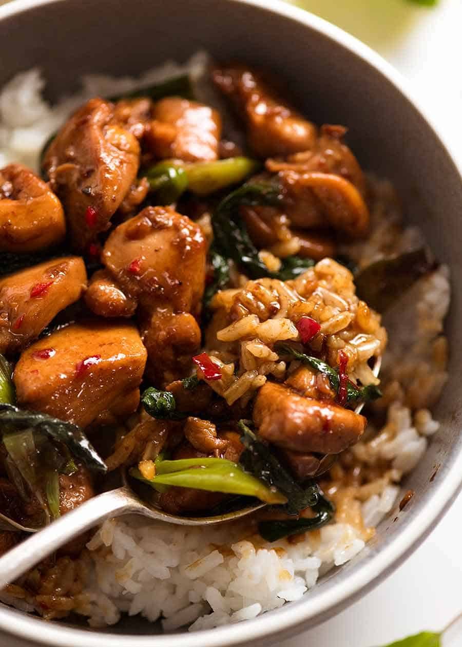 Close up of Thai Basil Chicken served over Jasmin rice in a blue bowl, ready to be eaten