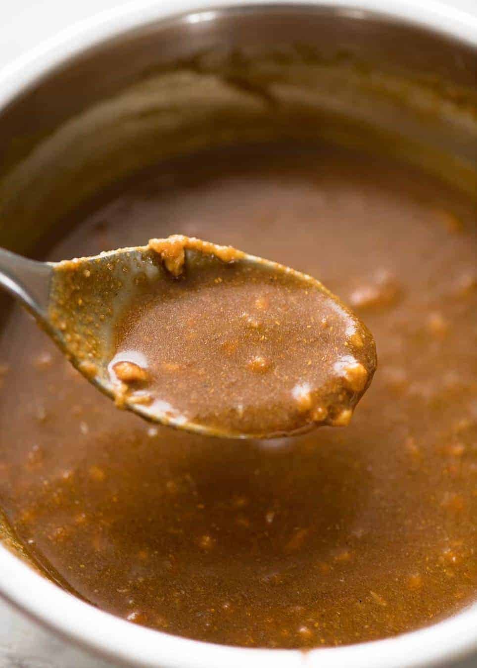 Close up of spoon scooping up Satay Sauce for stir fries