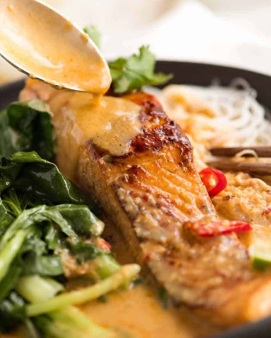 Spoon drizzling Coconut Lime Sauce over Coconut Poached Salmon