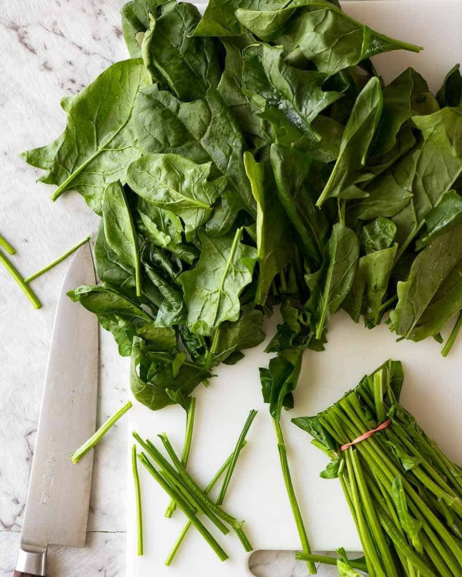 Raw spinach being prepared for Garlic Sautéed Spinach