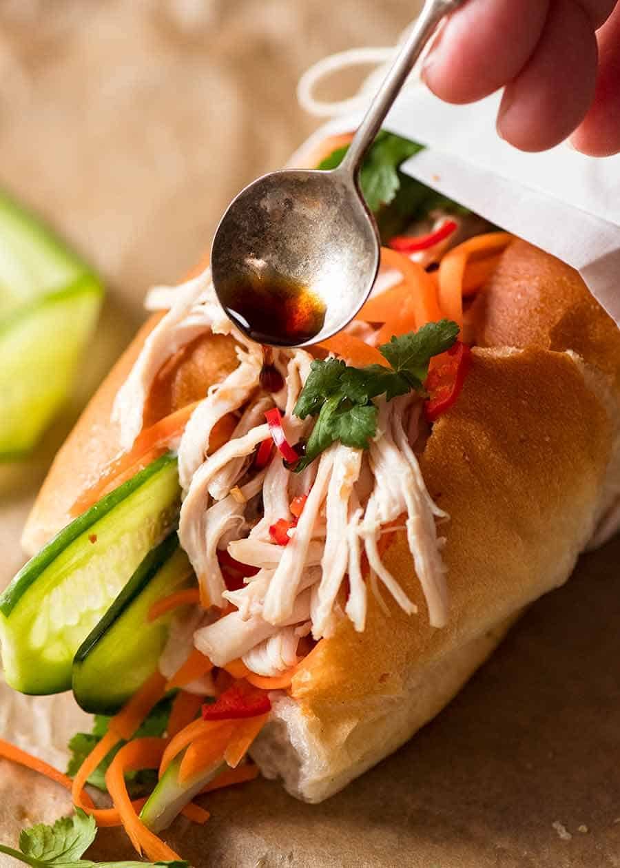Drizzling sauce over Shredded Chicken Banh Mi