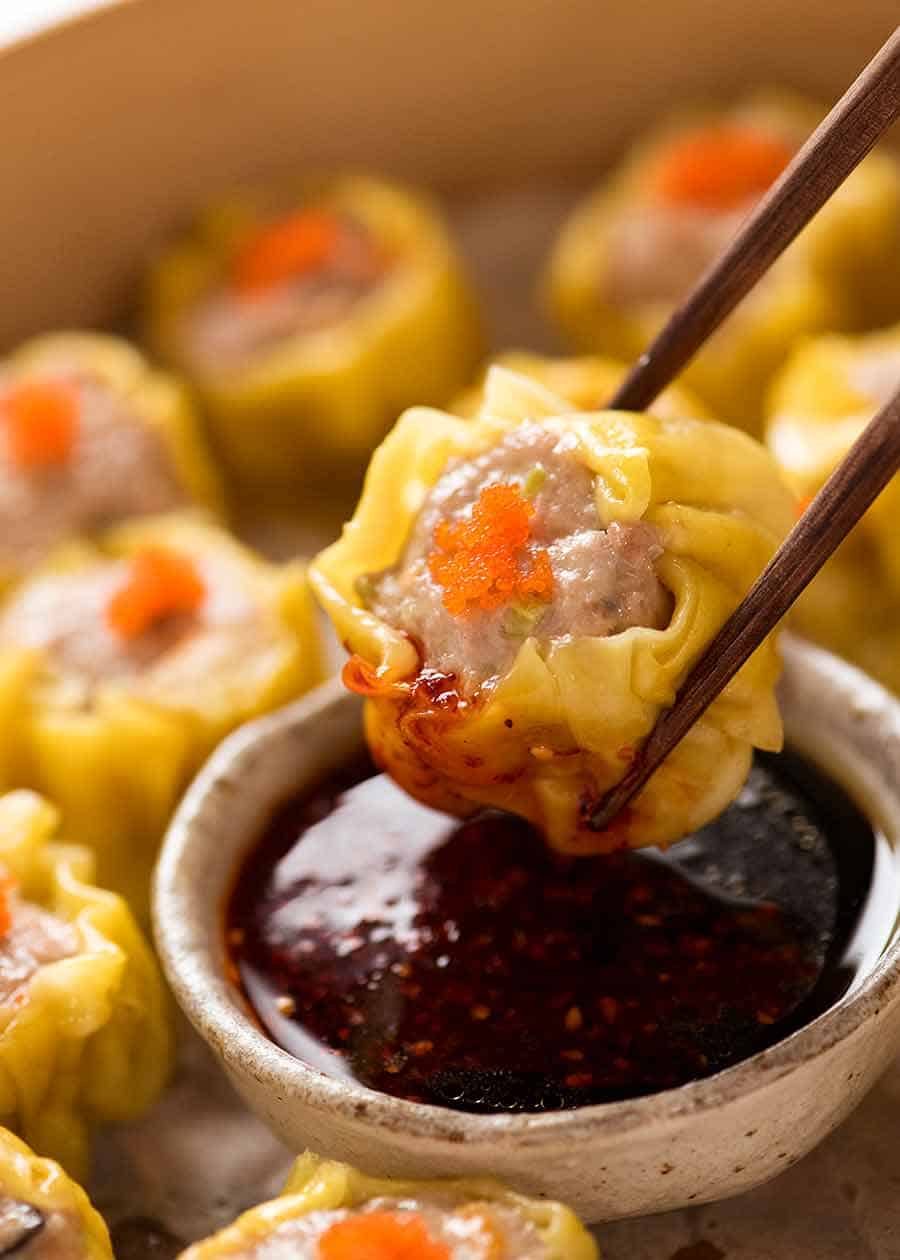 Close up of Siu Mai (Chinese steamed dumpling) dipped in sauce