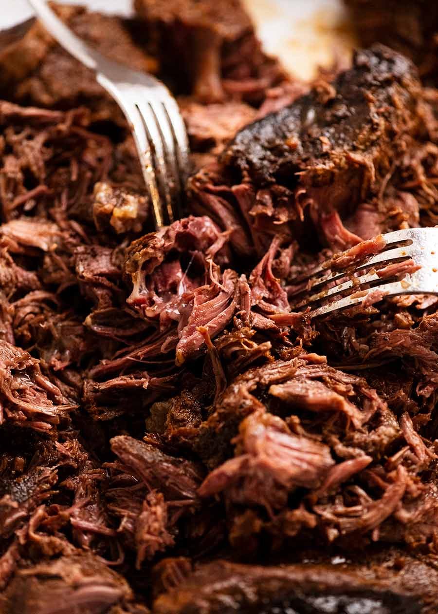 Using forks to shred Beef Barbacoa