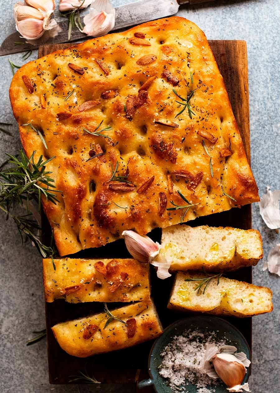 Overhead photo of Rosemary Garlic Focaccia on a wooden board, ready to be served